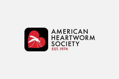 Logo of the American Heartworm Society, established by veterinarians in 1974, featuring a red heart with a stylized white mosquito silhouette inside a black box, next to the text "American Heartworm Society est. 1974".